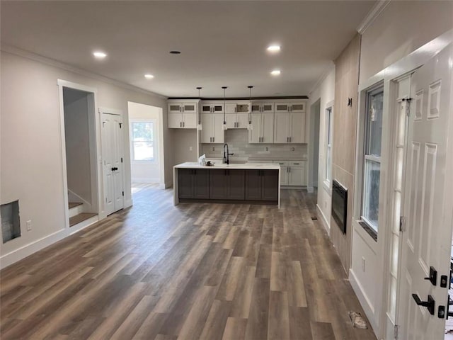 kitchen featuring dark wood finished floors, decorative backsplash, ornamental molding, glass insert cabinets, and white cabinetry