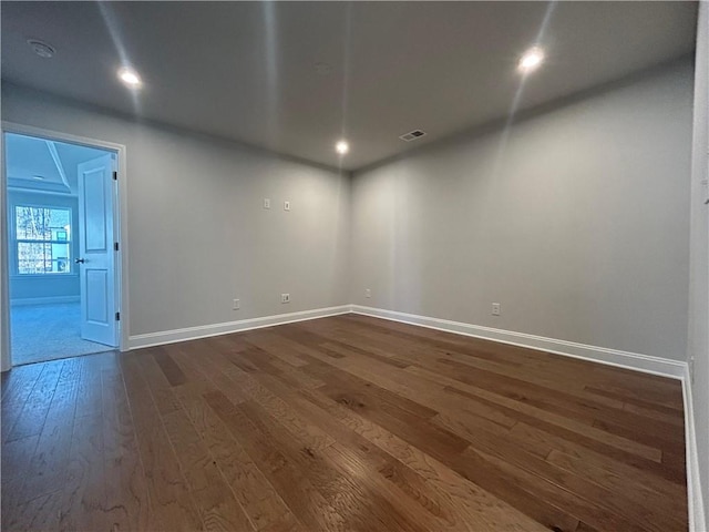 unfurnished room with dark wood-style flooring, recessed lighting, visible vents, and baseboards