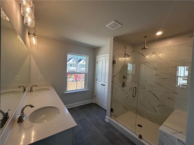 bathroom with visible vents, a sink, and a marble finish shower