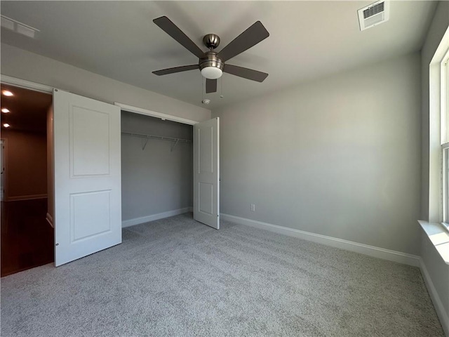 unfurnished bedroom with baseboards, visible vents, a closet, and light colored carpet