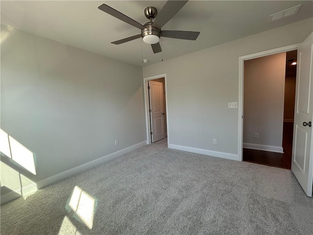 unfurnished bedroom featuring carpet floors, visible vents, baseboards, and a ceiling fan