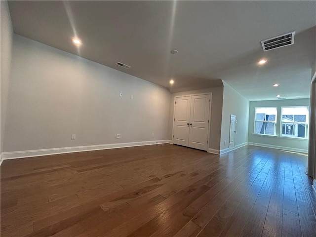 unfurnished room featuring recessed lighting, dark wood finished floors, visible vents, and baseboards