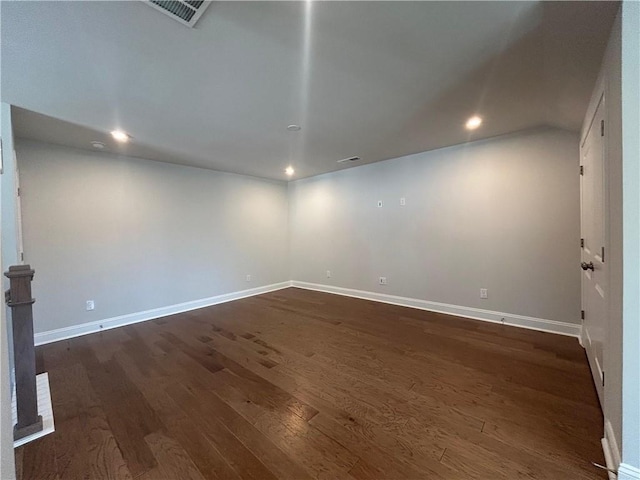 spare room featuring baseboards, visible vents, and dark wood-style flooring