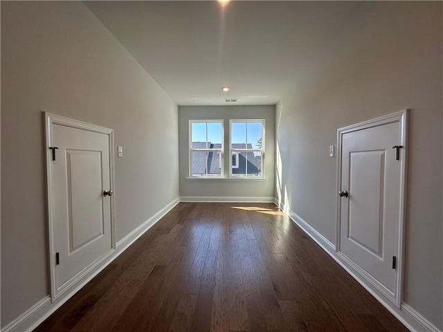 bonus room featuring visible vents, baseboards, and dark wood finished floors