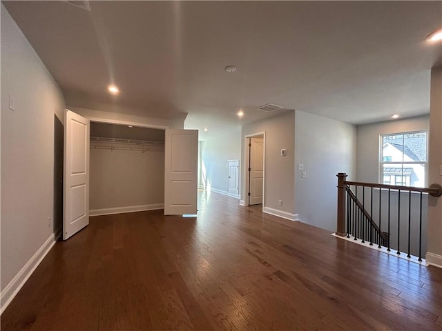 spare room with baseboards, visible vents, dark wood-style flooring, and recessed lighting