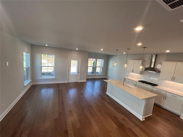 kitchen with dark wood-style flooring, open floor plan, light countertops, decorative backsplash, and wall chimney exhaust hood