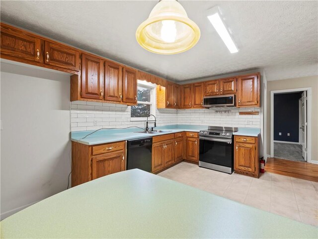 205 Crooked Pine Trl, Baldwin, GA 30511 - kitchen featuring stainless steel appliances, a sink, brown cabinetry, tasteful backsplash, and light countertops