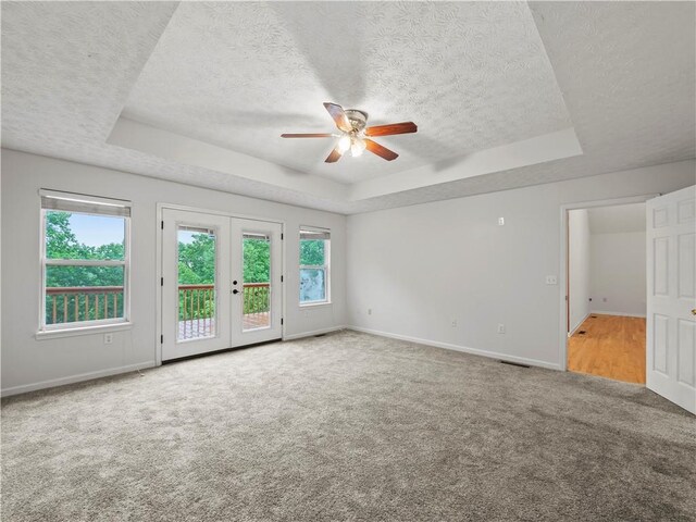 205 Crooked Pine Trl, Baldwin, GA 30511 - carpeted spare room featuring a tray ceiling, a textured ceiling, a ceiling fan, baseboards, and french doors