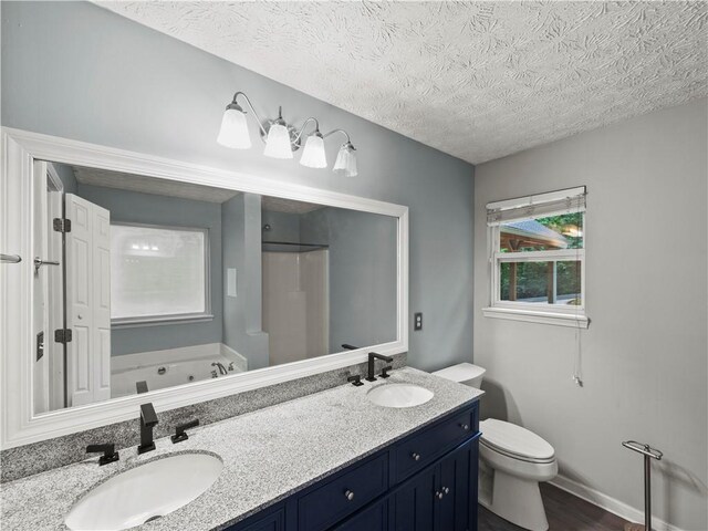205 Crooked Pine Trl, Baldwin, GA 30511 - full bathroom featuring a textured ceiling, double vanity, a jetted tub, toilet, and wood finished floors