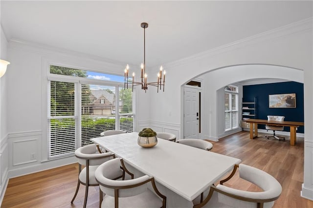 602 Davenport Pl, Canton, GA 30115 - dining space with light wood finished floors, arched walkways, crown molding, a chandelier, and a decorative wall