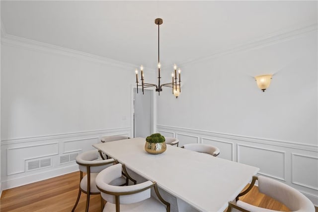 602 Davenport Pl, Canton, GA 30115 - dining space with a decorative wall, crown molding, a chandelier, light wood-style floors, and wainscoting