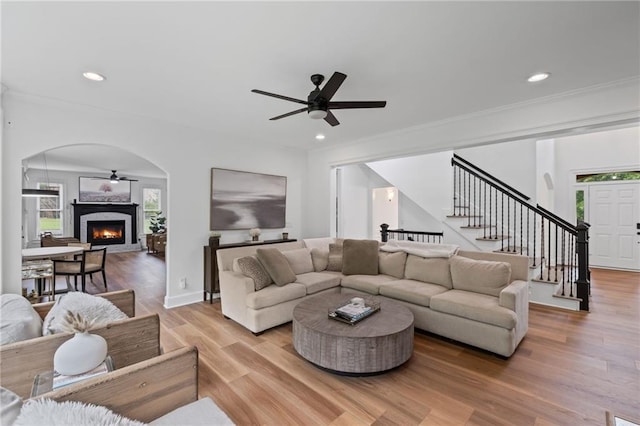 602 Davenport Pl, Canton, GA 30115 - living area featuring a ceiling fan, stairs, arched walkways, light wood-type flooring, and a lit fireplace