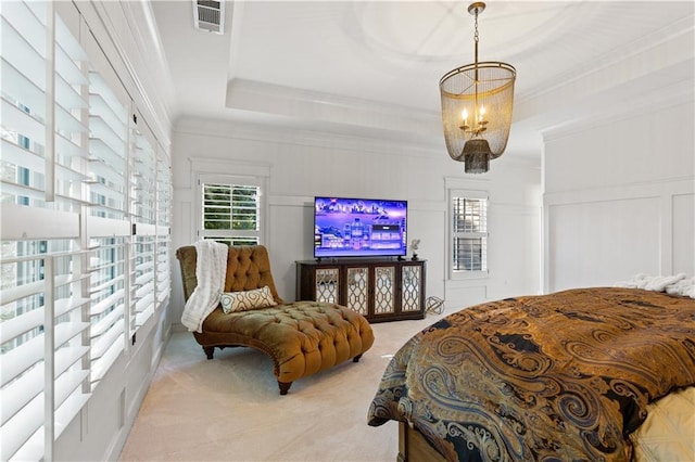 carpeted bedroom featuring an inviting chandelier, crown molding, and a raised ceiling