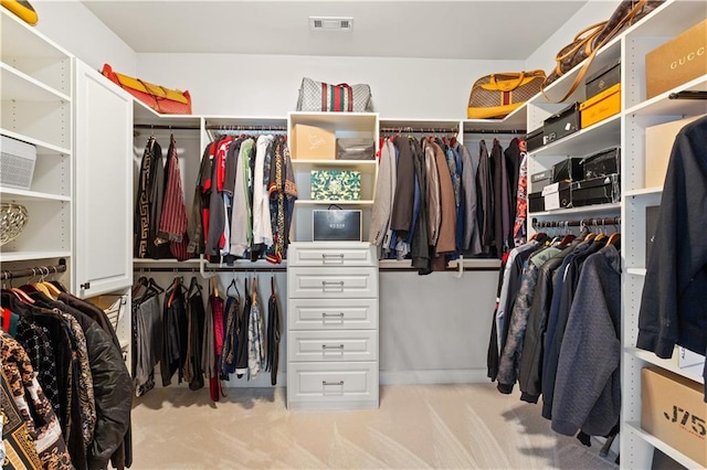 walk in closet featuring light colored carpet