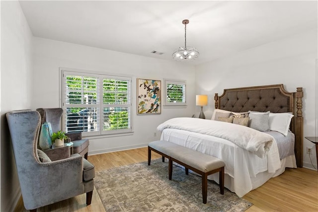 bedroom featuring hardwood / wood-style floors and a notable chandelier