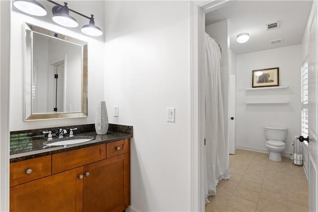 bathroom featuring tile patterned flooring, vanity, and toilet