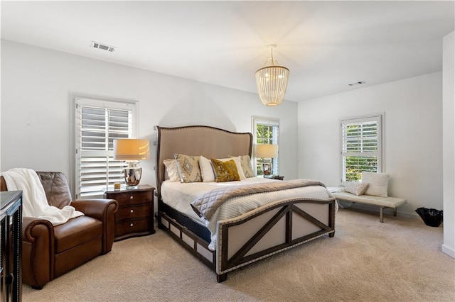 bedroom featuring light colored carpet and a notable chandelier