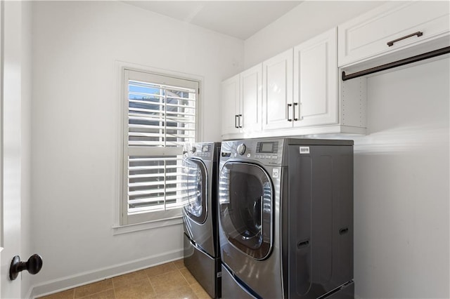 clothes washing area with washing machine and dryer, cabinets, and light tile patterned flooring