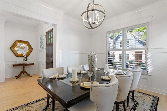 dining area with an inviting chandelier, wood-type flooring, and crown molding