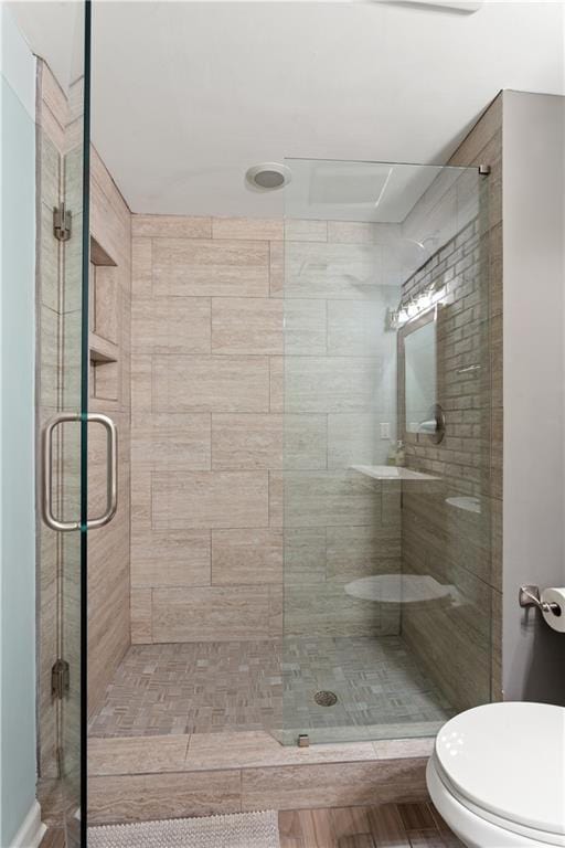 bathroom with an enclosed shower and toilet