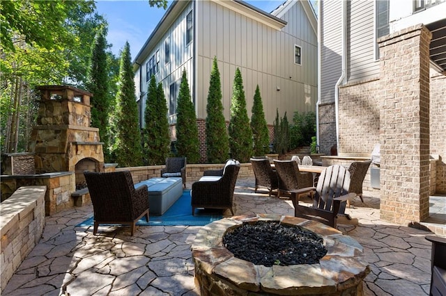 view of patio / terrace with an outdoor stone fireplace and an outdoor fire pit