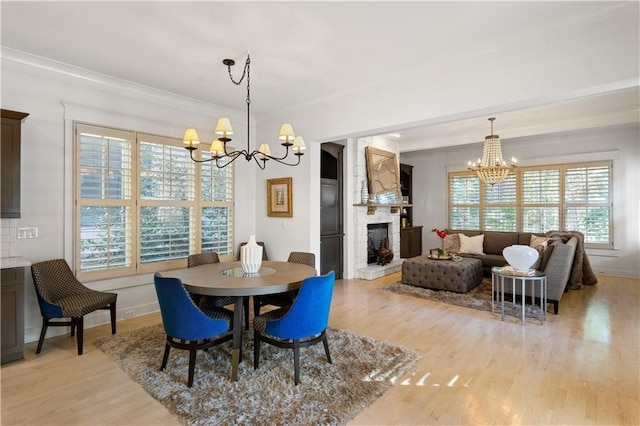 dining space featuring crown molding, light hardwood / wood-style floors, and a chandelier