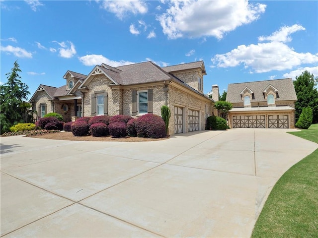 view of side of property with brick siding, a garage, and concrete driveway