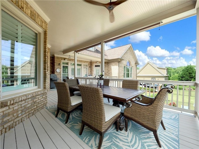 wooden deck with a ceiling fan and outdoor dining space