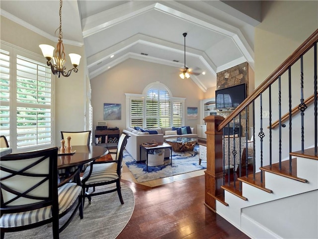 dining room featuring ceiling fan with notable chandelier, lofted ceiling, hardwood / wood-style flooring, and stairway