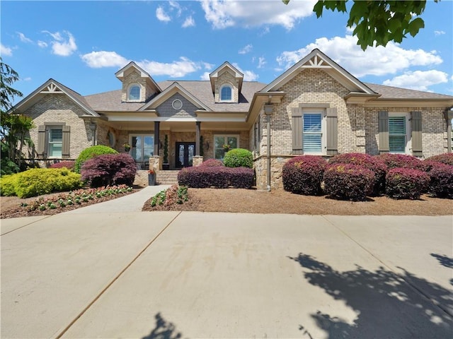 view of front of property featuring brick siding and covered porch