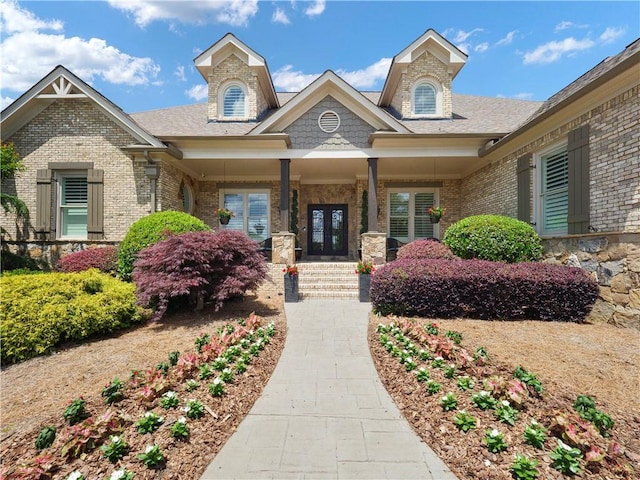 exterior space with brick siding, french doors, and covered porch