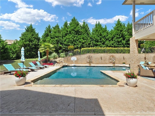 view of swimming pool featuring fence, a fenced in pool, and a patio