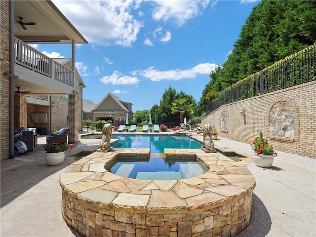 view of pool with a patio, ceiling fan, fence, and a pool with connected hot tub