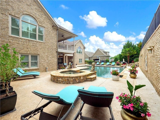 outdoor pool featuring an in ground hot tub and a patio area