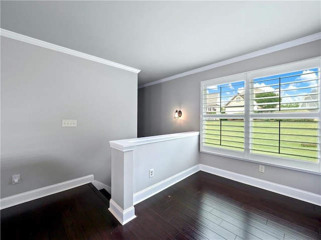 spare room with wood-type flooring, baseboards, and crown molding
