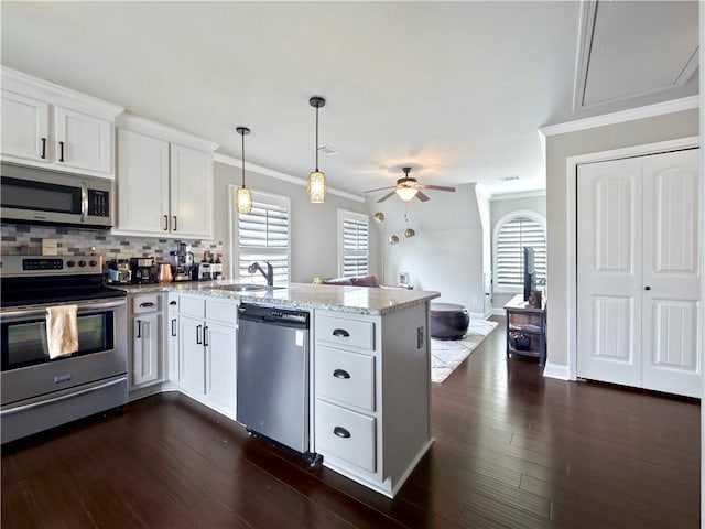 kitchen with ceiling fan, a sink, a peninsula, stainless steel appliances, and white cabinetry