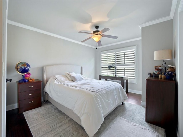 bedroom with baseboards, ornamental molding, a ceiling fan, and wood finished floors