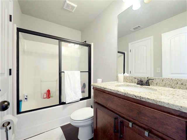 bathroom with shower / bath combination with glass door, toilet, visible vents, and vanity