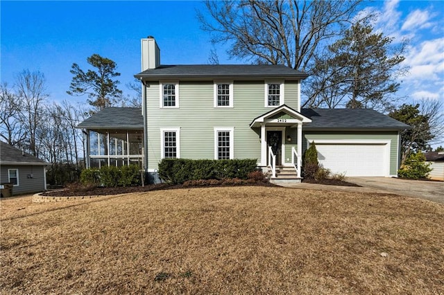 colonial-style house with a garage, a sunroom, and a front yard