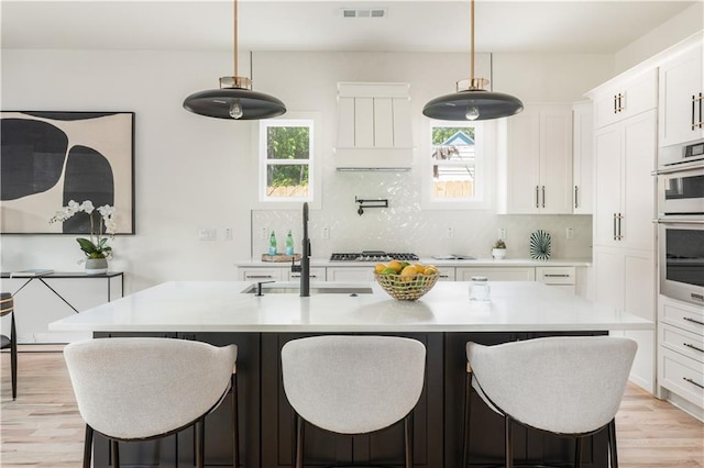 kitchen with plenty of natural light, light countertops, visible vents, and a sink