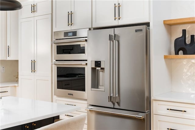 kitchen featuring appliances with stainless steel finishes, open shelves, and light countertops