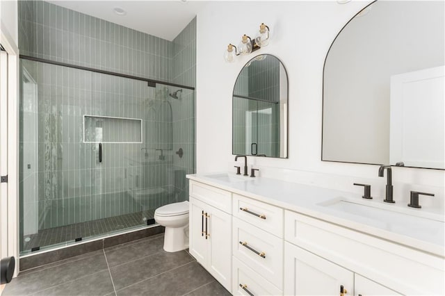 full bathroom with tile patterned flooring, a stall shower, a sink, and toilet