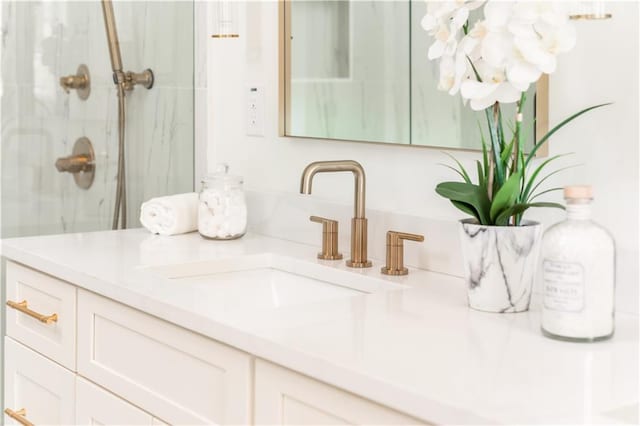 bathroom featuring vanity and a marble finish shower