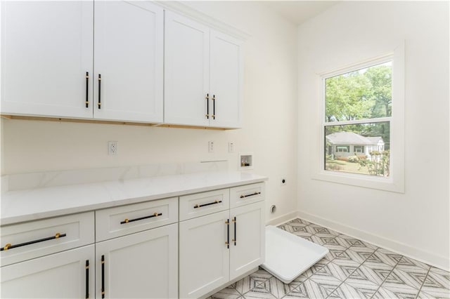 laundry area with baseboards, hookup for a washing machine, cabinet space, light floors, and electric dryer hookup