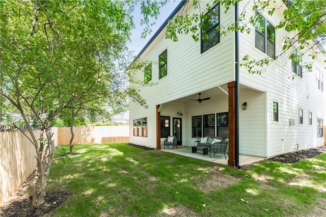 rear view of property with fence, outdoor lounge area, a patio area, ceiling fan, and a yard