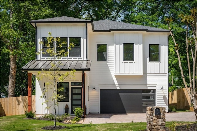 view of front of home with board and batten siding, an attached garage, and fence