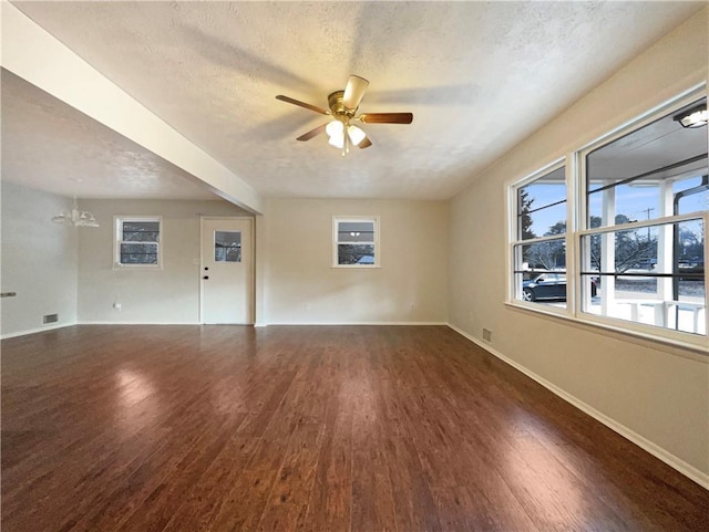 unfurnished room featuring dark hardwood / wood-style flooring, ceiling fan with notable chandelier, and a textured ceiling