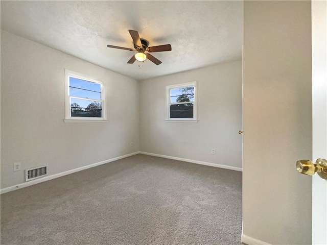 spare room featuring ceiling fan, carpet floors, and a healthy amount of sunlight