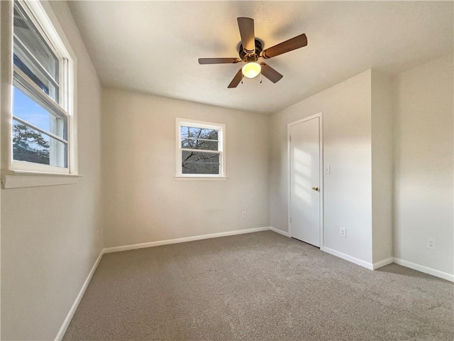 carpeted spare room with ceiling fan