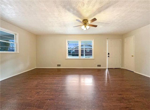 empty room with a healthy amount of sunlight, ceiling fan, and a textured ceiling